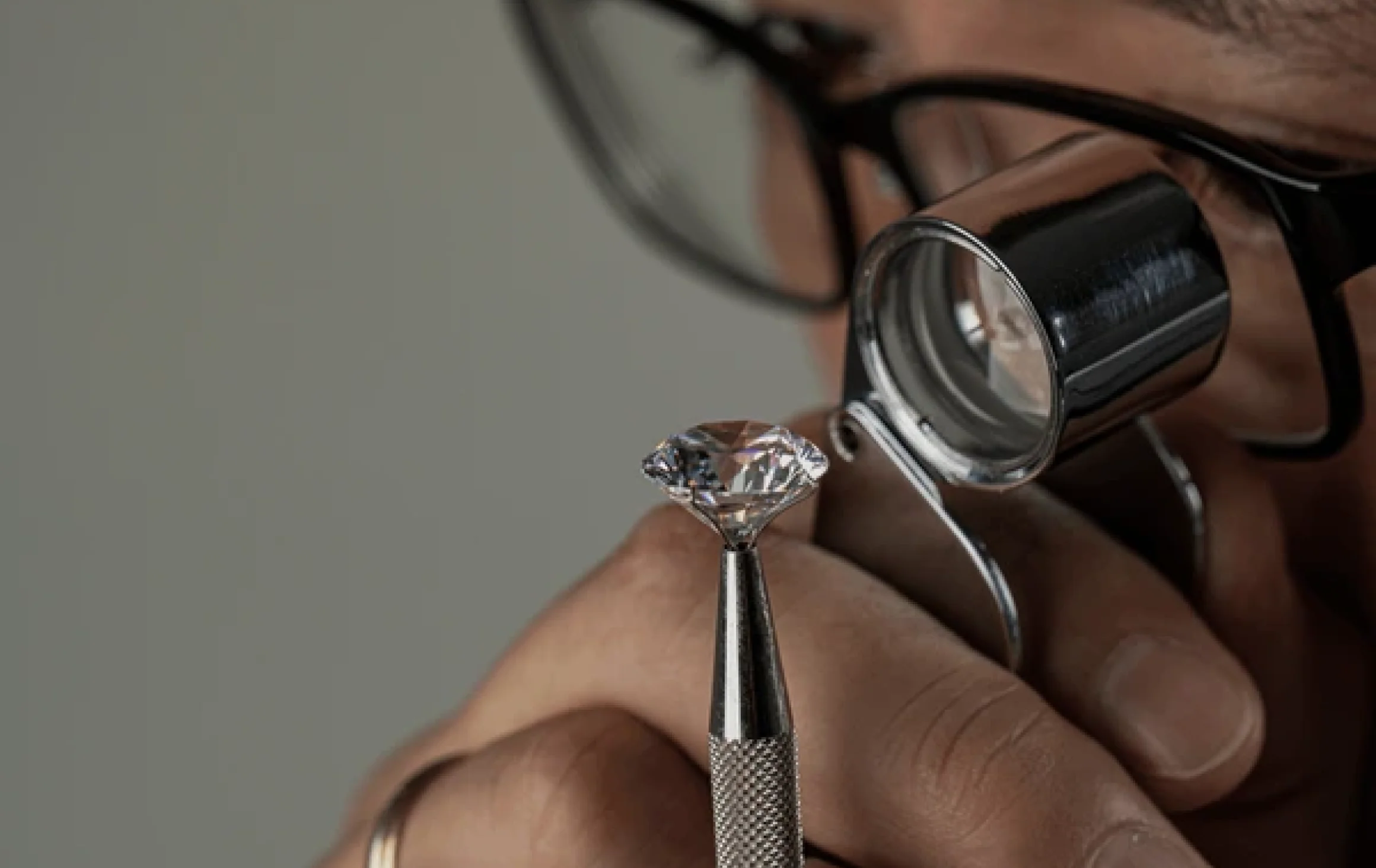 jeweler examines diamond closely using loupe focusing intently holding gem precision